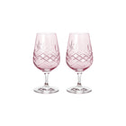 To fasettslipte krystallglass i rosa med skandinavisk design fra Frederik Bagger, elegant og funksjonelt.