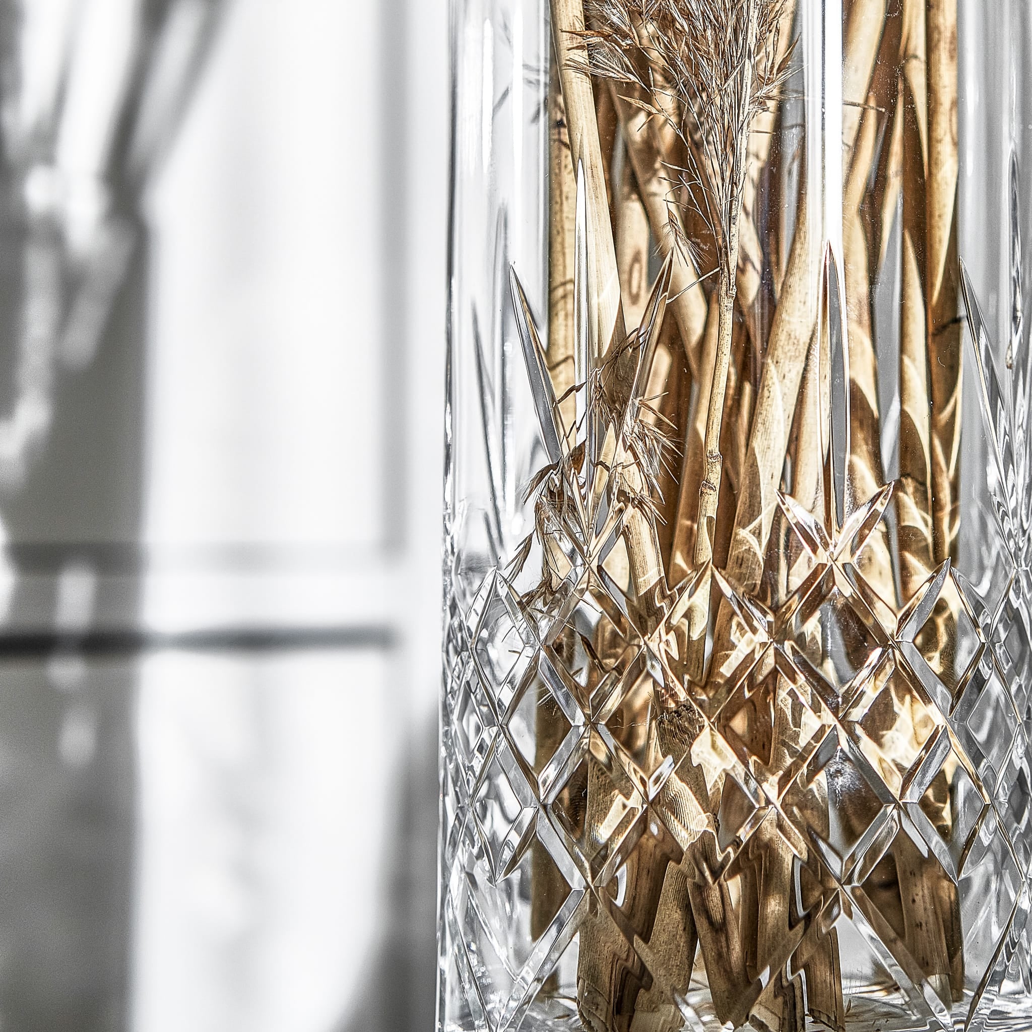 Skandinavisk vase i klart fasettslipt glass med diamantmønster og tørkede naturdetaljer fra Frederik Bagger