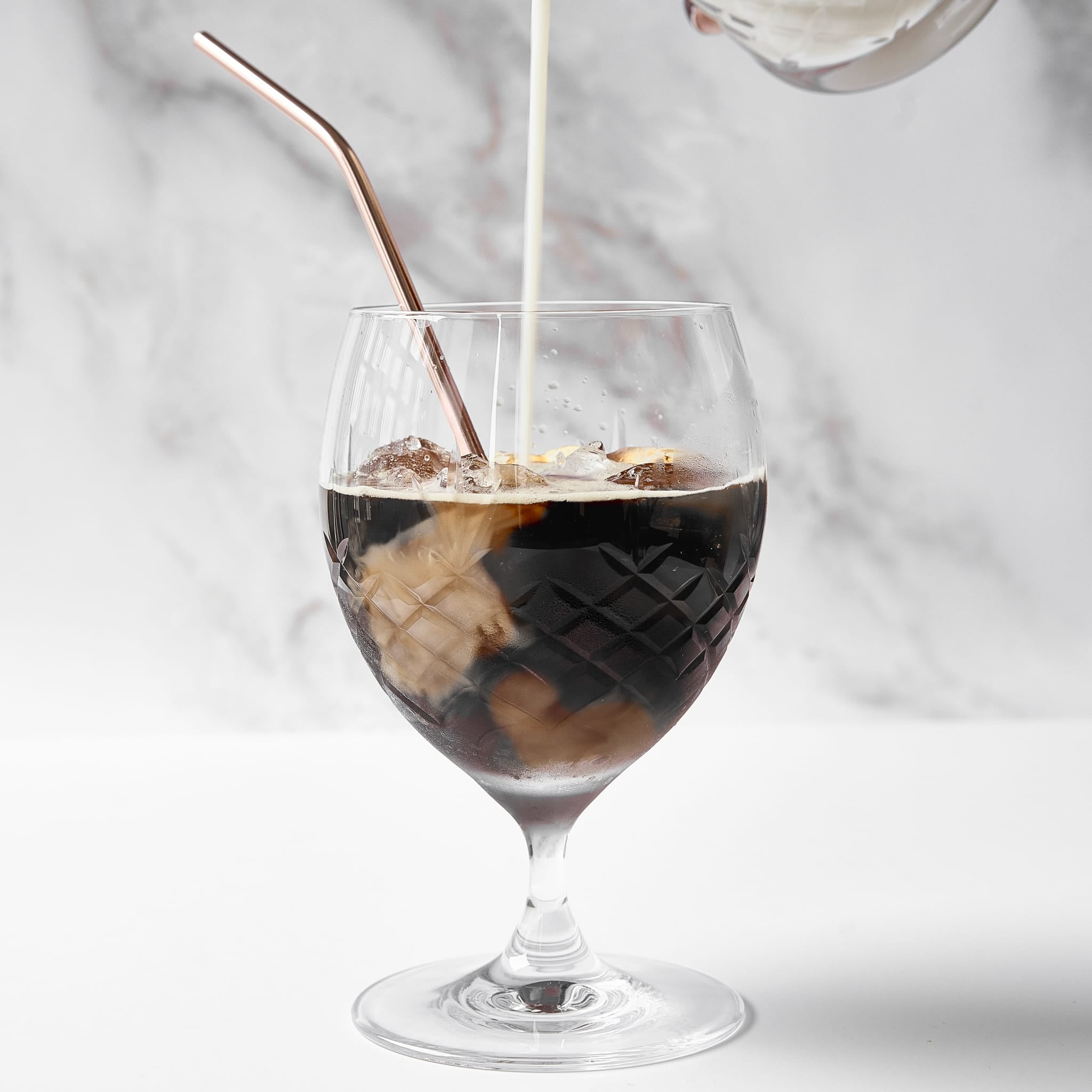Krystallglass med diamantmønster fylt med iskald kaffe og melk, elegant skandinavisk design fra Frederik Bagger