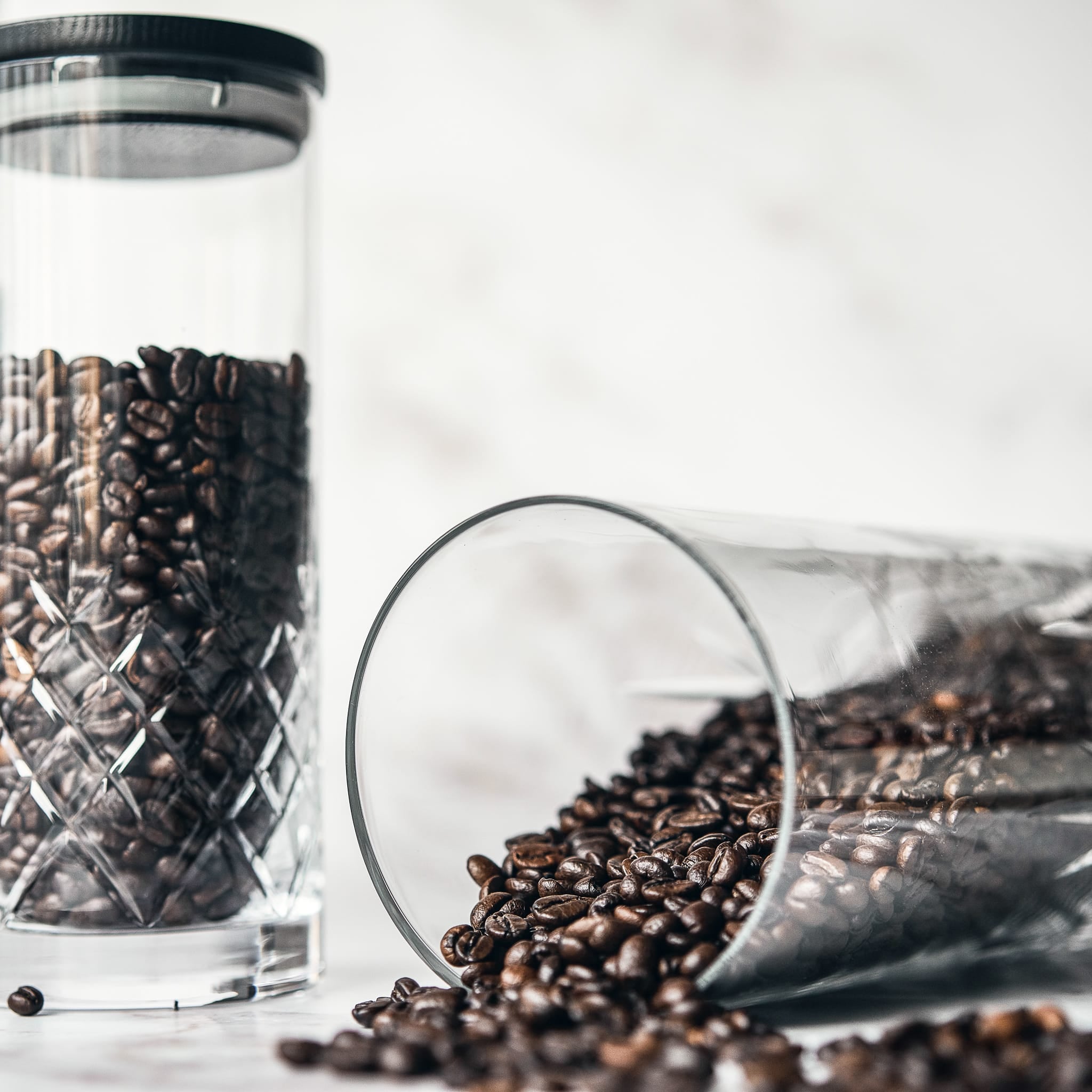 Krystallglassbeholdere med rillet mønster fylt med kaffebønner i skandinavisk interiørstil