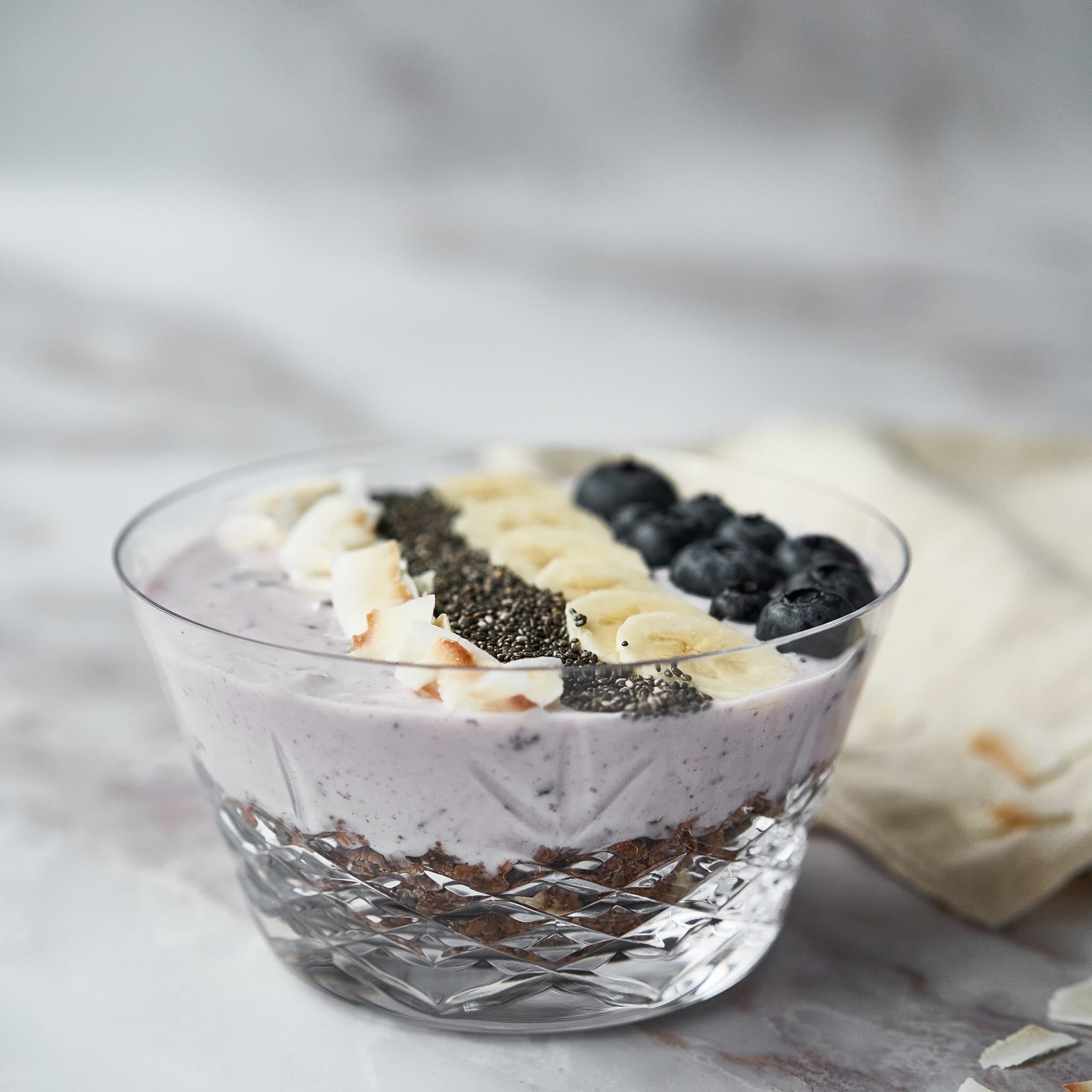 Klar skål med fasettslipt design fra Frederik Bagger fylt med yoghurt og bær i skandinavisk stil