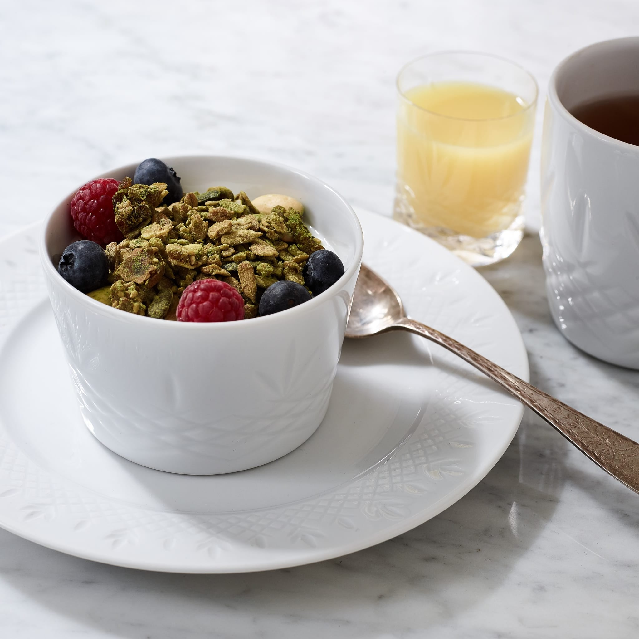 Hvitt porselenssidetallerken med rillet mønster fra Frederik Bagger med yoghurt og bær på marmorbord