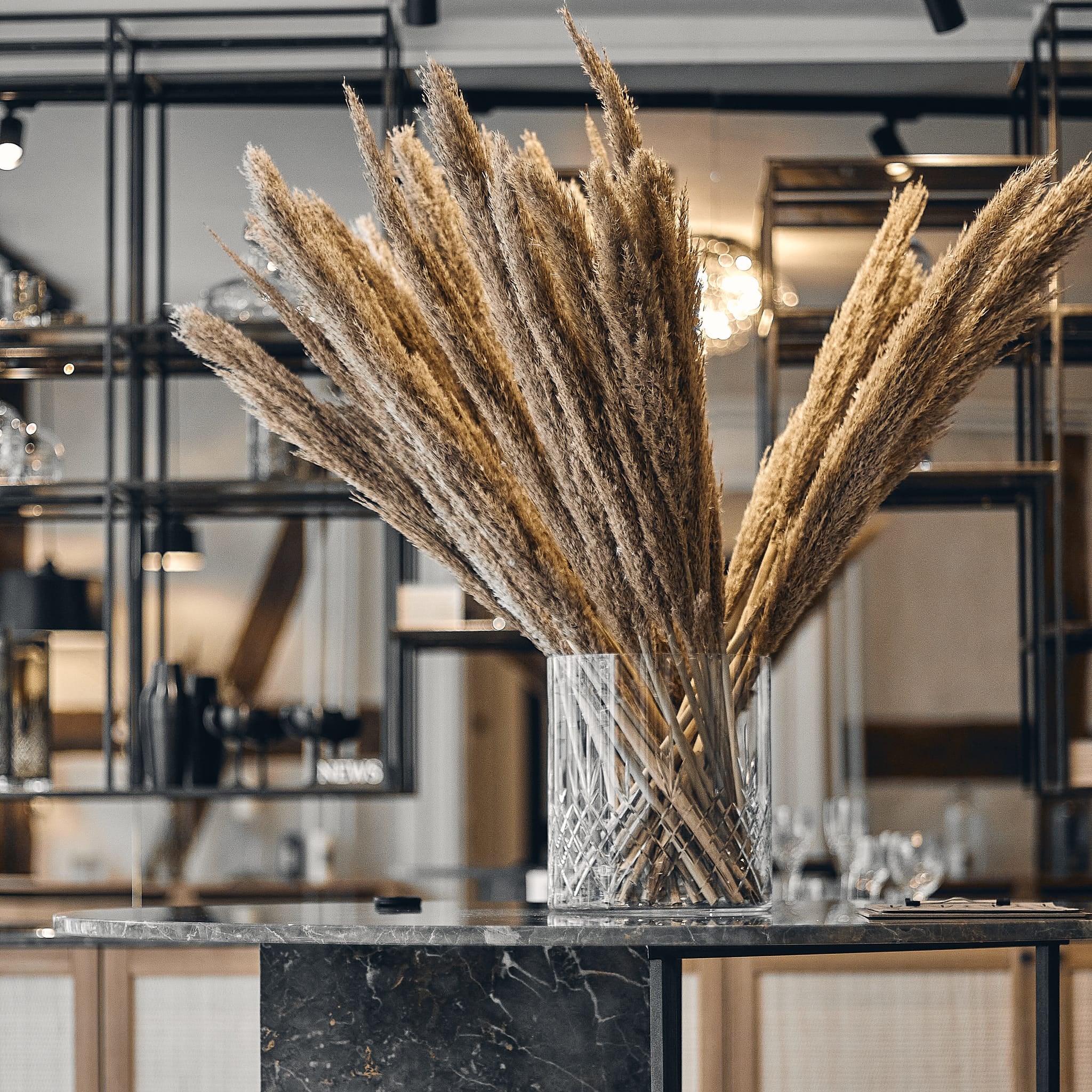 Klart glass med diamantmønster fra Frederik Bagger fylt med tørkede dekorative strå i moderne interiør