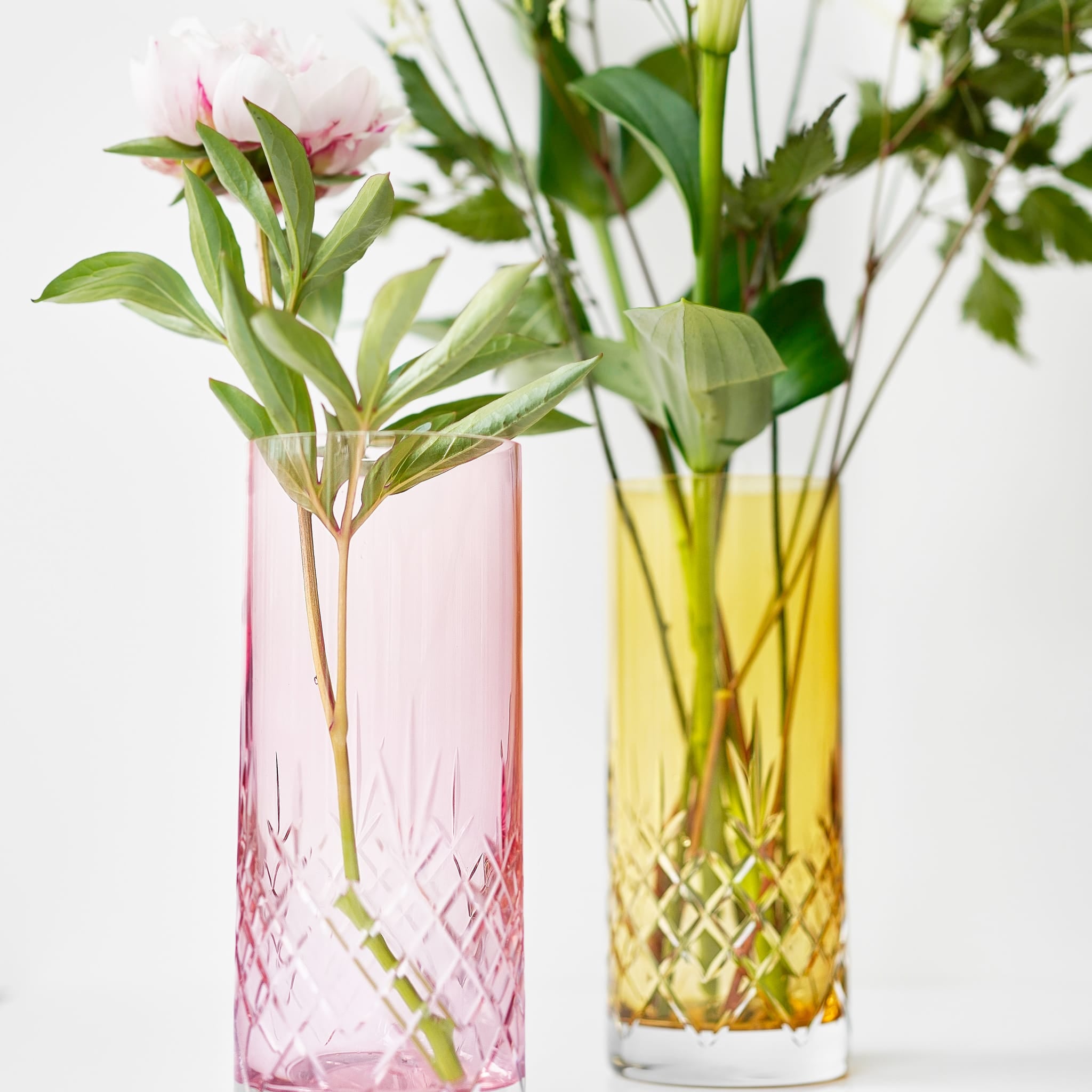 To fargede vaser i krystallglass med diamantmønster i minimalistisk skandinavisk design.