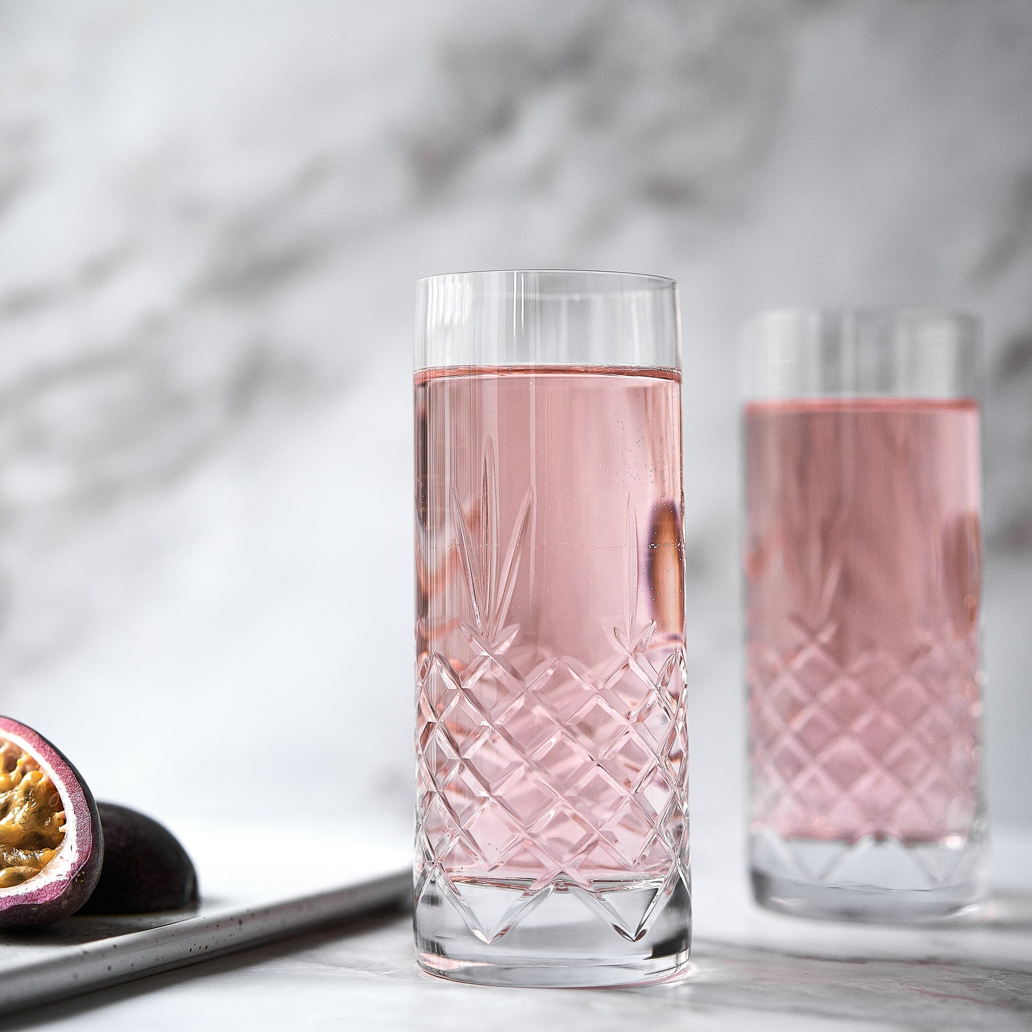 krystallglass med fasettslipt diamantmønster og skandinavisk design fylt med rosa drikke fra Frederik Bagger