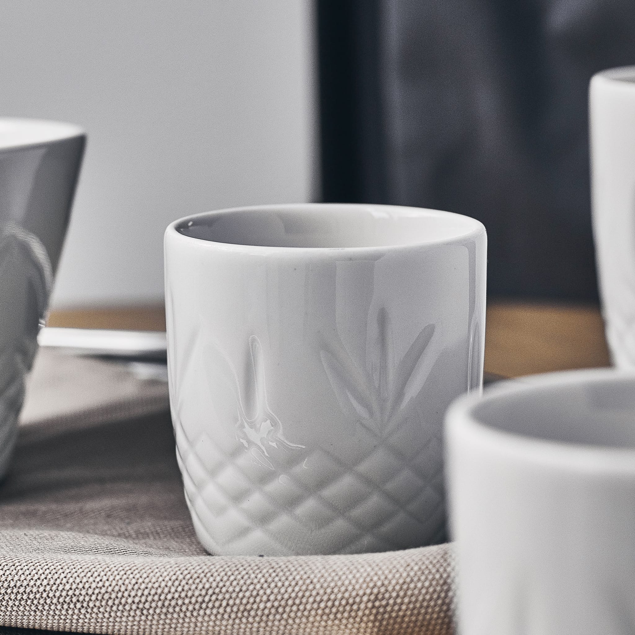 Hvitt porselenskopp med skandinavisk, tidløst design og rillete detaljer inspirert av krystallglass.