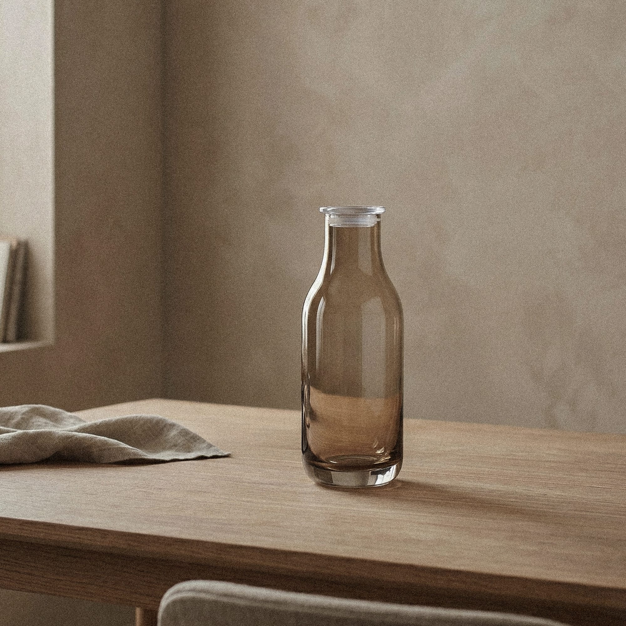 Skandinavisk karaffel i røykfarget glass fra Frederik Bagger, minimalistisk design for interiør og servering.