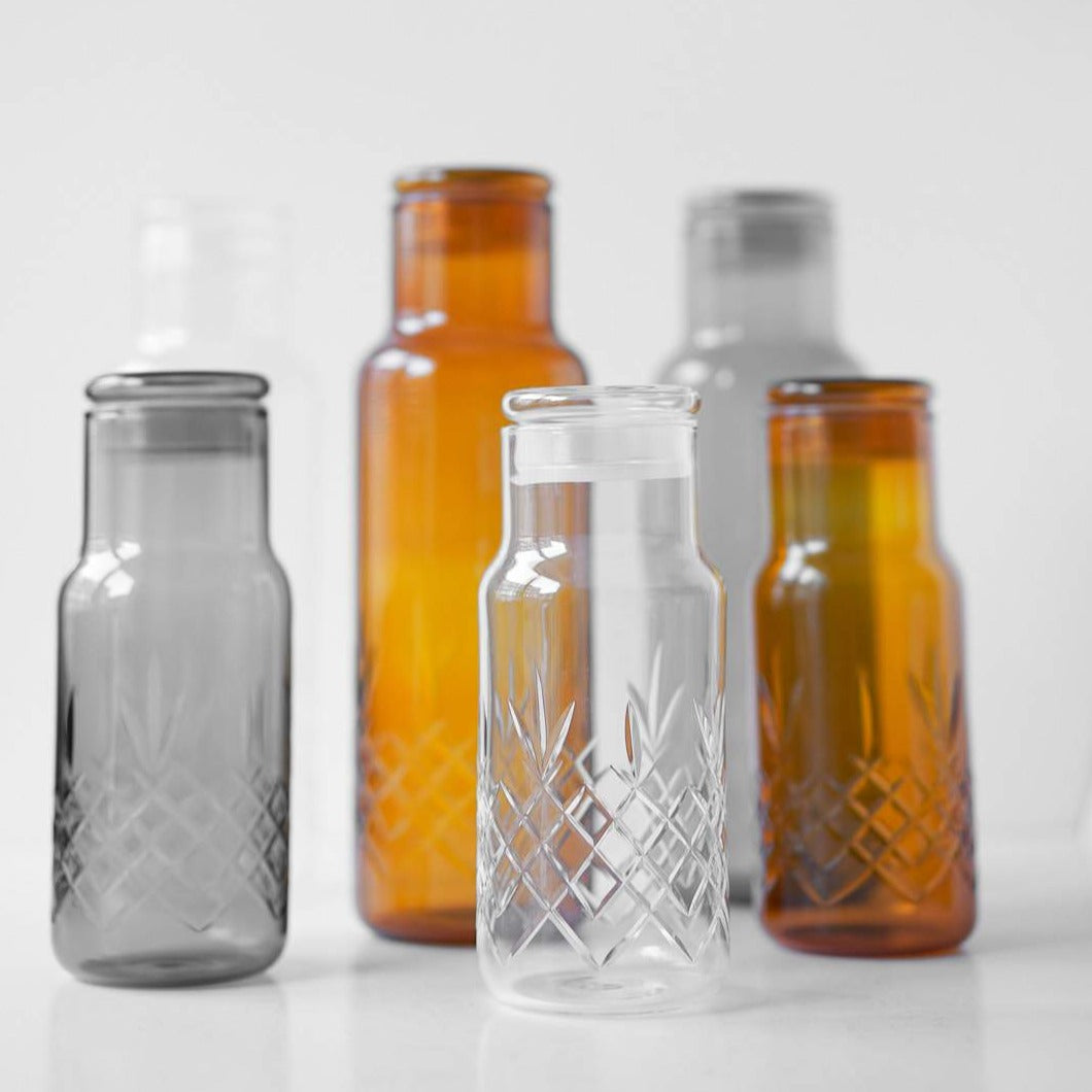 Skandinaviske vannkarafler i klart og røykfarget glass med elegant rillet mønster fra Frederik Bagger.