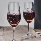 To vinglass med diamantmønstret klart glass fra Frederik Bagger fylt med mørk portvin på bordet.