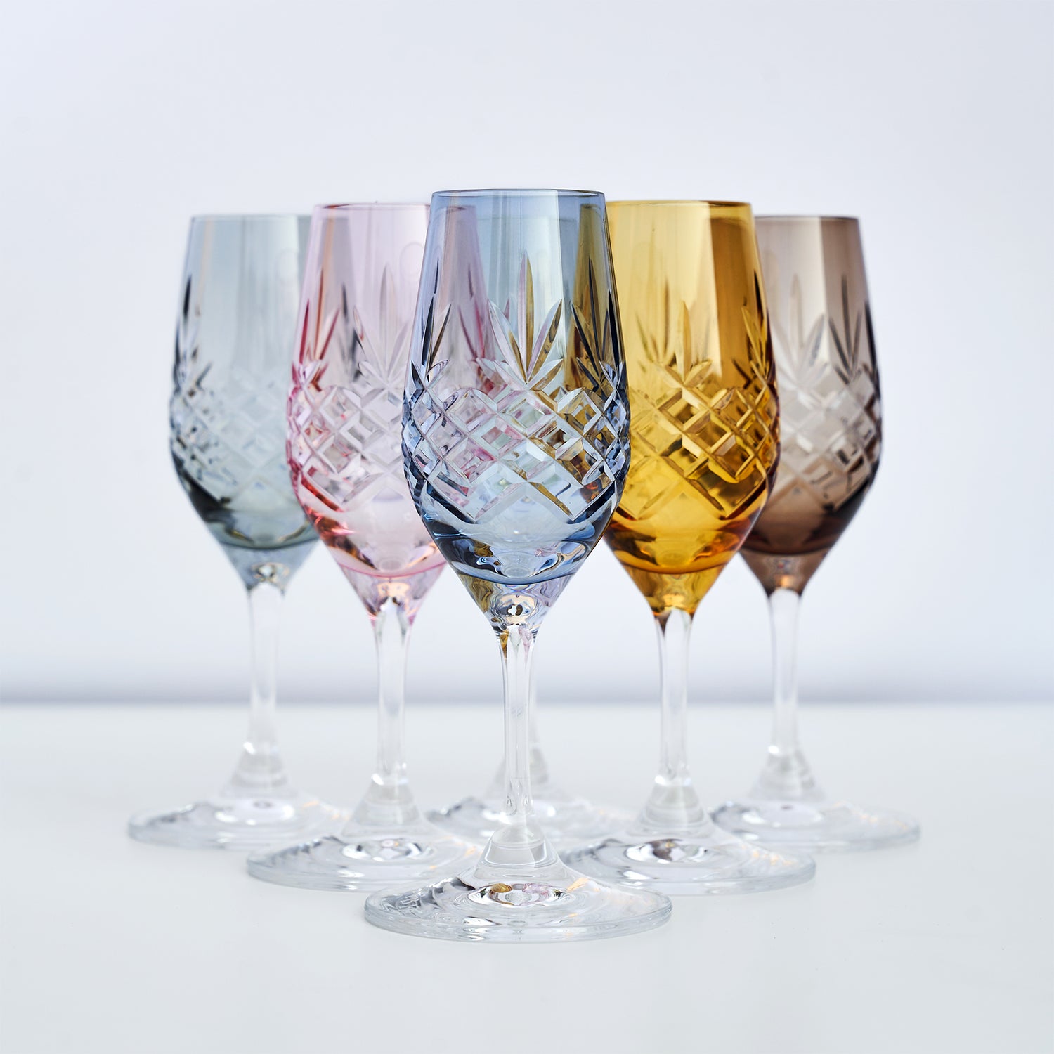 Skandinaviske vinglass med diamantmønster i klart, blått, rosa, gult og røykfarget glass fra Frederik Bagger.